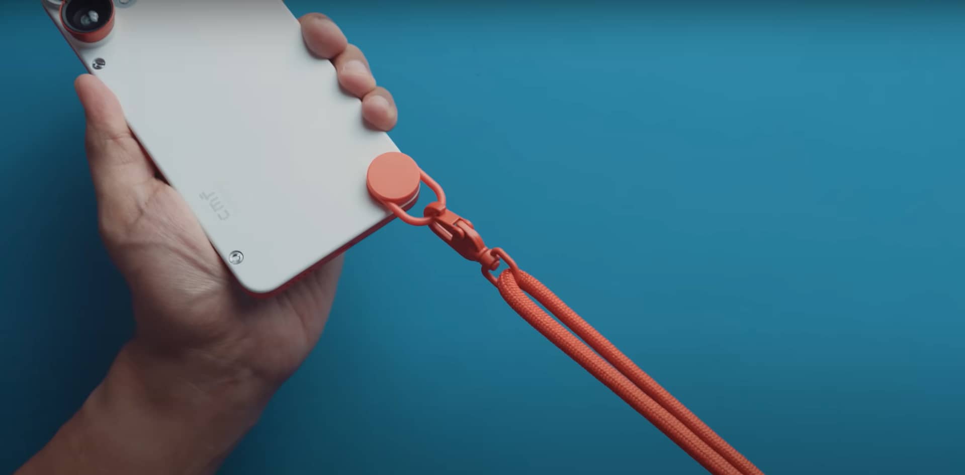 A bright orange lanyard attaches to the CMF Phone 2 Pro